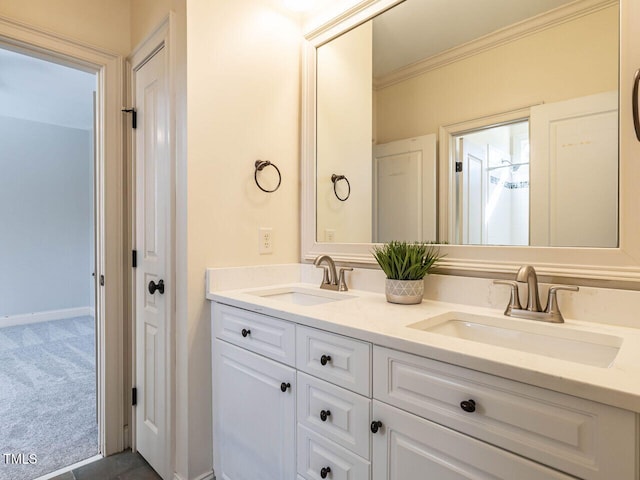 bathroom featuring double vanity, baseboards, ornamental molding, and a sink