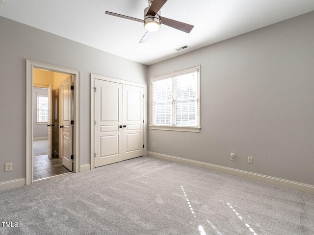 unfurnished bedroom with light carpet, visible vents, and baseboards