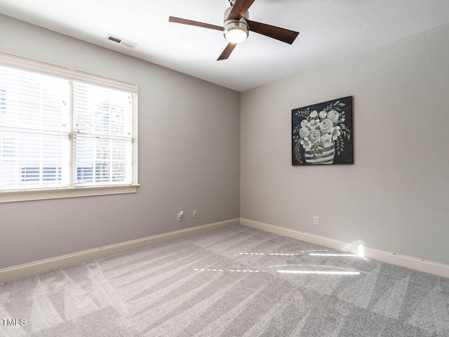 spare room featuring a ceiling fan, visible vents, light carpet, and baseboards