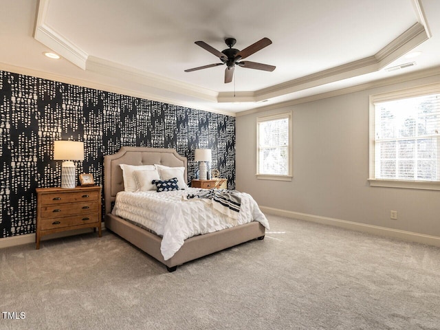 carpeted bedroom with ornamental molding, a raised ceiling, visible vents, and baseboards