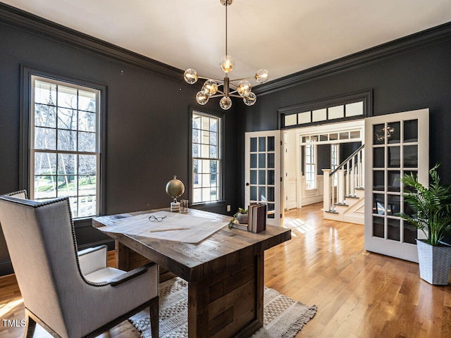 office area with a chandelier, french doors, ornamental molding, and light wood-type flooring