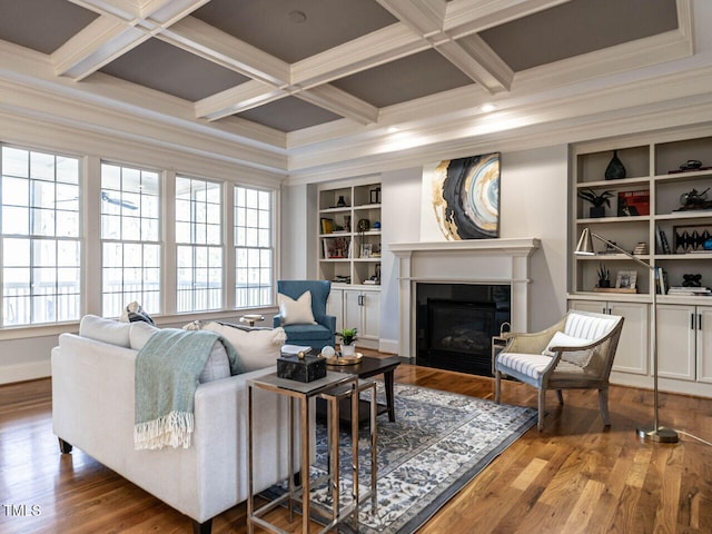 living area featuring wood finished floors, coffered ceiling, plenty of natural light, and a fireplace with flush hearth