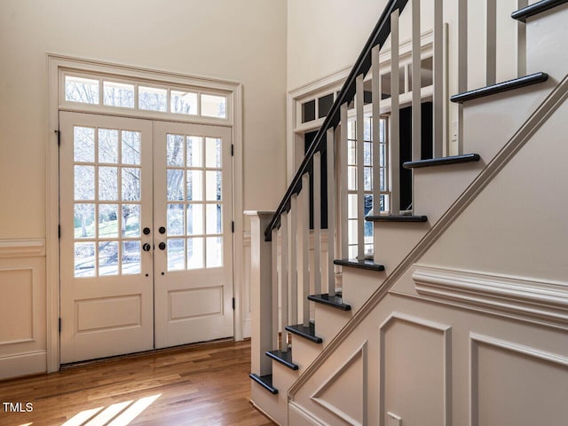 doorway with light wood-type flooring, french doors, and stairway