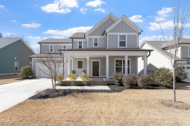 view of front of home with board and batten siding, covered porch, driveway, and a front lawn