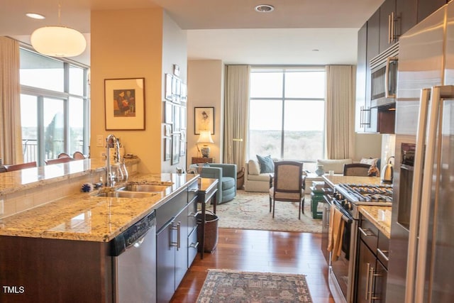 kitchen with open floor plan, appliances with stainless steel finishes, a sink, and a wealth of natural light