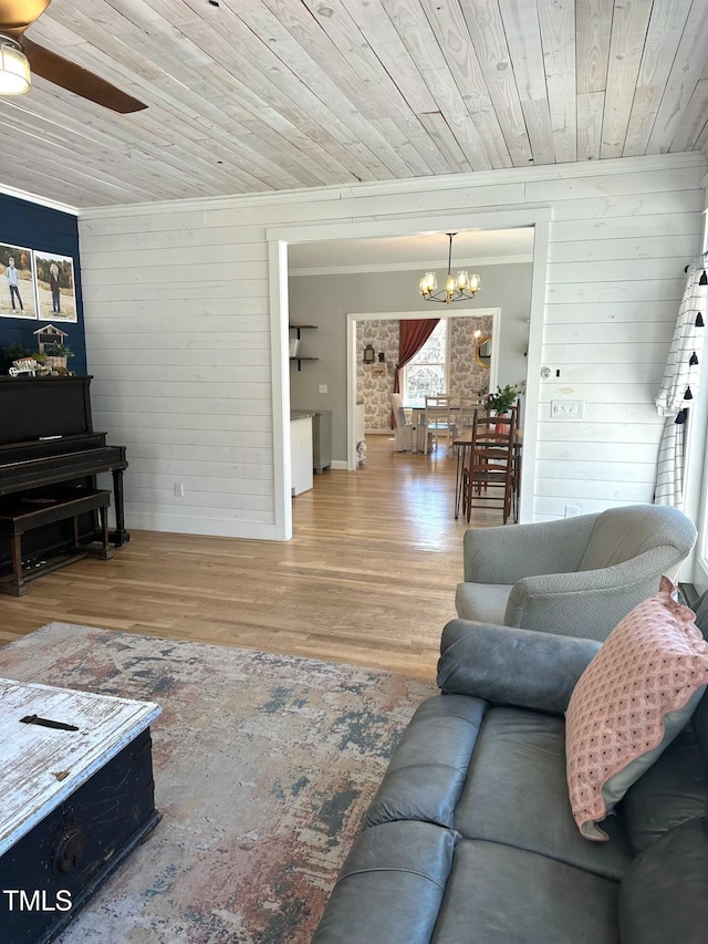 living room featuring wood ceiling, crown molding, wood finished floors, and ceiling fan with notable chandelier