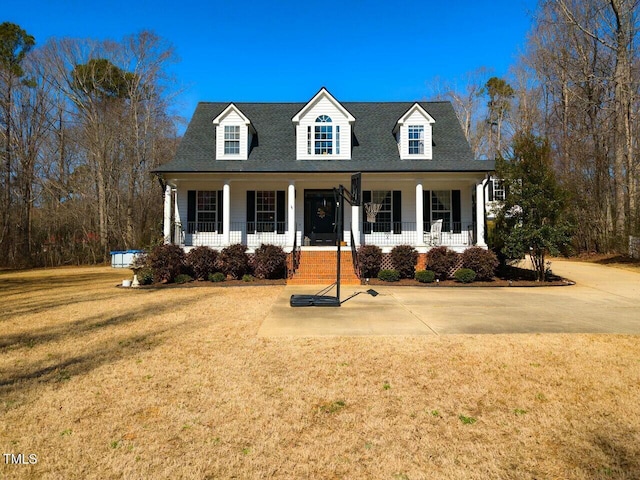 cape cod home with a porch, a shingled roof, and a front lawn