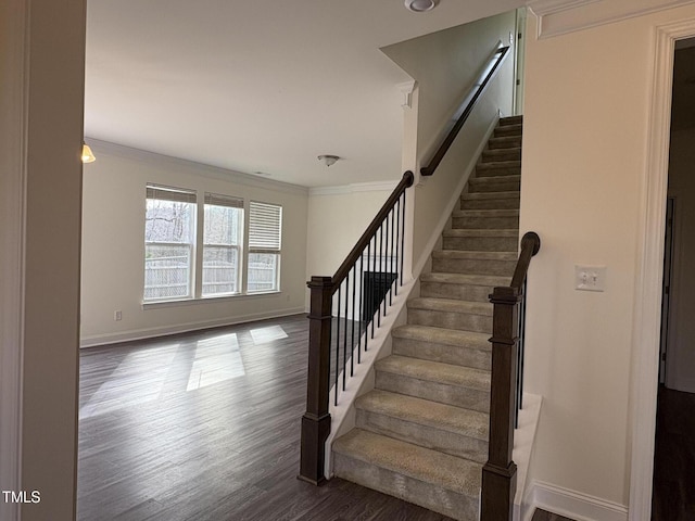 stairs featuring baseboards, ornamental molding, and wood finished floors