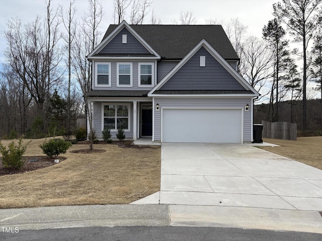 craftsman house featuring a garage, driveway, roof with shingles, and a front yard