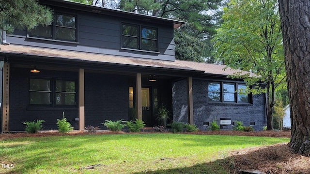 view of front of property featuring crawl space, a front yard, and brick siding