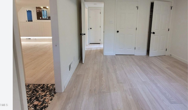 unfurnished bedroom featuring light wood-style flooring and baseboards