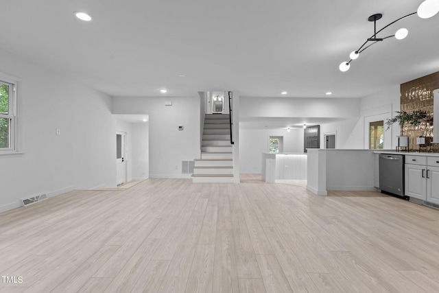 unfurnished living room featuring light wood-type flooring, visible vents, stairway, and recessed lighting