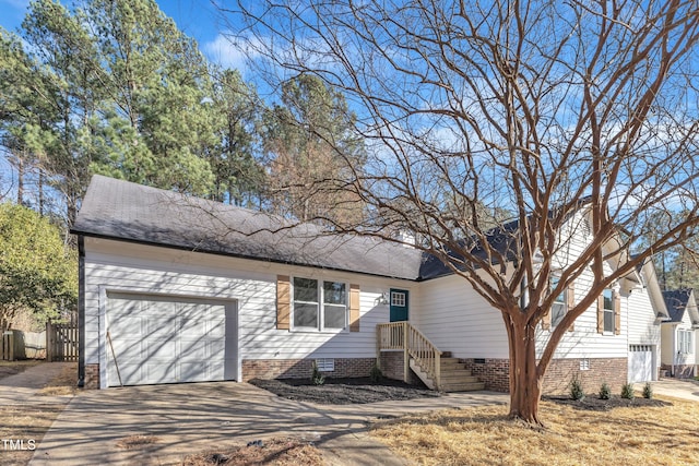 ranch-style home featuring crawl space, roof with shingles, an attached garage, and concrete driveway