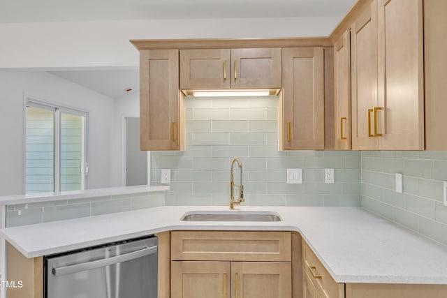 kitchen featuring dishwasher, backsplash, a sink, and light brown cabinets