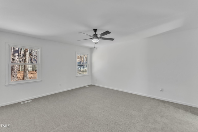 unfurnished room with carpet flooring, ceiling fan, visible vents, and baseboards