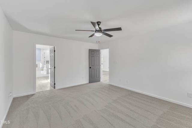 unfurnished bedroom with carpet floors, connected bathroom, baseboards, and a ceiling fan