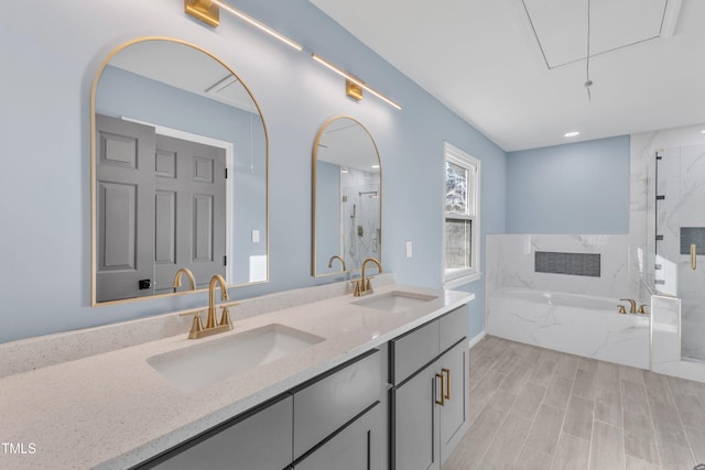 bathroom featuring a bath, double vanity, a sink, and a marble finish shower