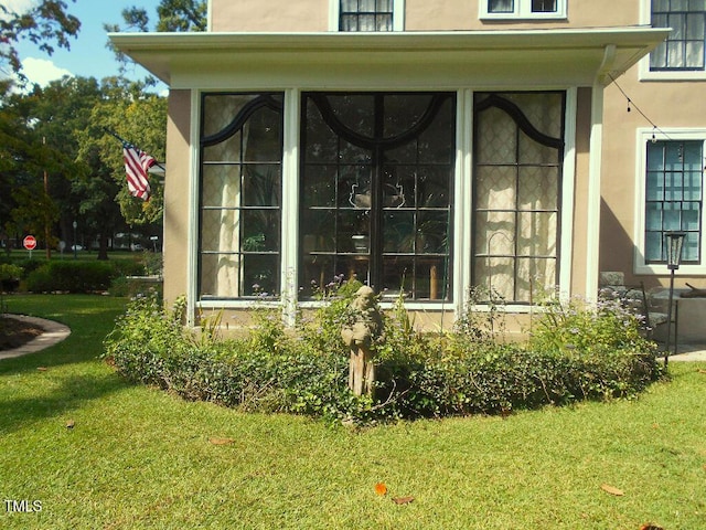 exterior space with a lawn and stucco siding