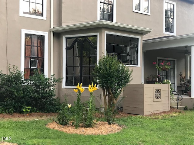 view of side of property featuring a lawn and stucco siding