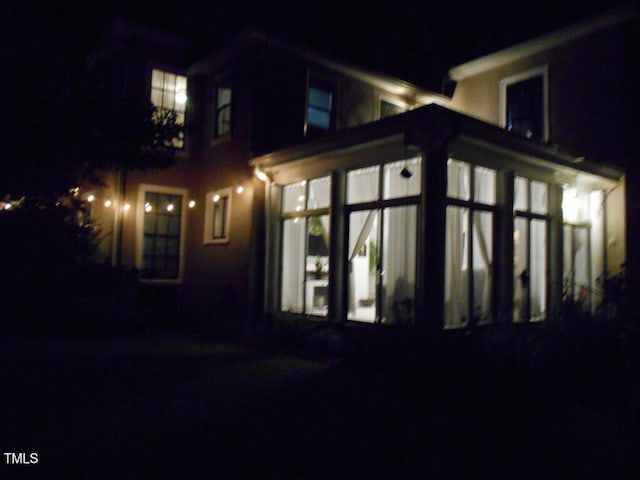 property exterior at night featuring a sunroom