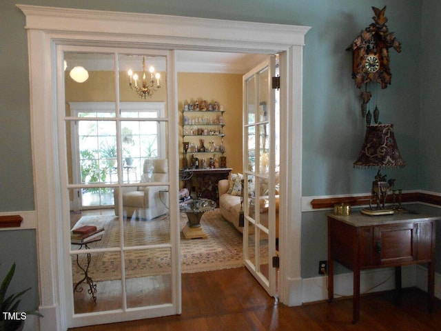 doorway to outside featuring dark wood-style floors and a chandelier