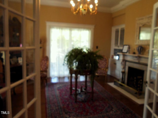 living area with a fireplace, ornamental molding, and a notable chandelier