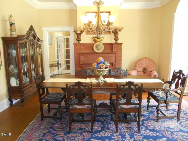 dining room featuring an inviting chandelier, wood finished floors, and crown molding