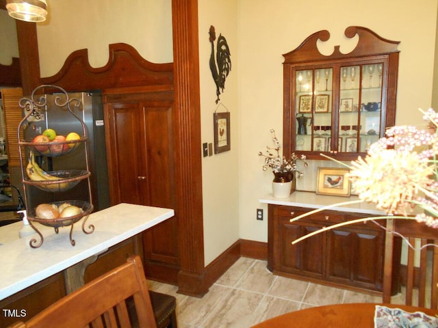 interior space with baseboards, light countertops, and light tile patterned flooring