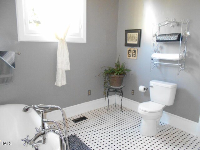 bathroom featuring toilet and baseboards