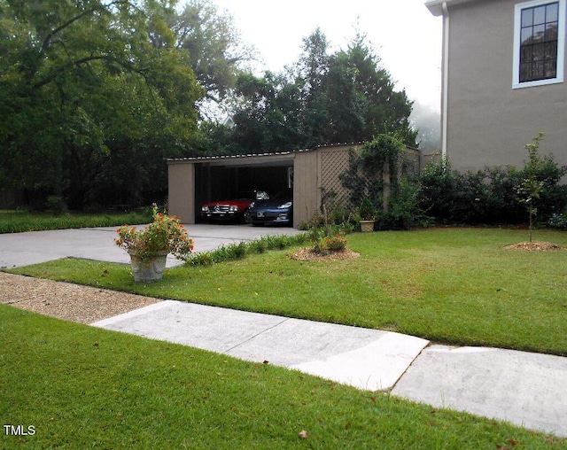 view of yard with a carport and concrete driveway