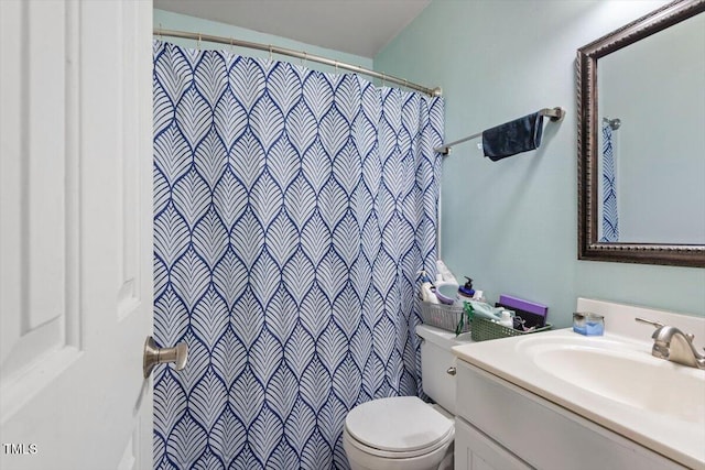 bathroom featuring toilet, a shower with shower curtain, and vanity