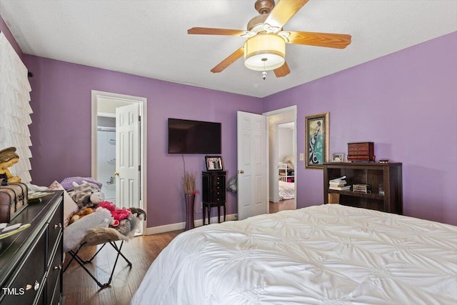 bedroom with ceiling fan, baseboards, and wood finished floors