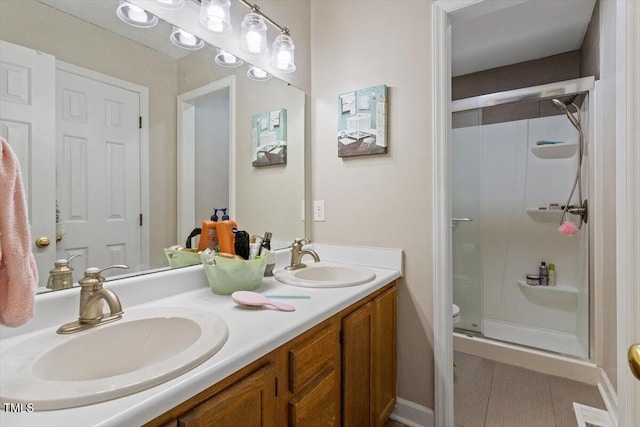 bathroom featuring tile patterned floors, a sink, a shower stall, and double vanity