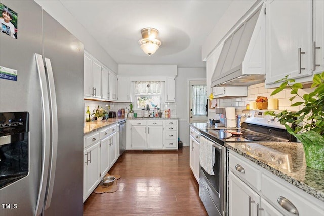 kitchen featuring custom exhaust hood, tasteful backsplash, white cabinetry, and stainless steel appliances