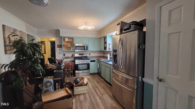 kitchen featuring stainless steel appliances, light wood finished floors, open shelves, and crown molding