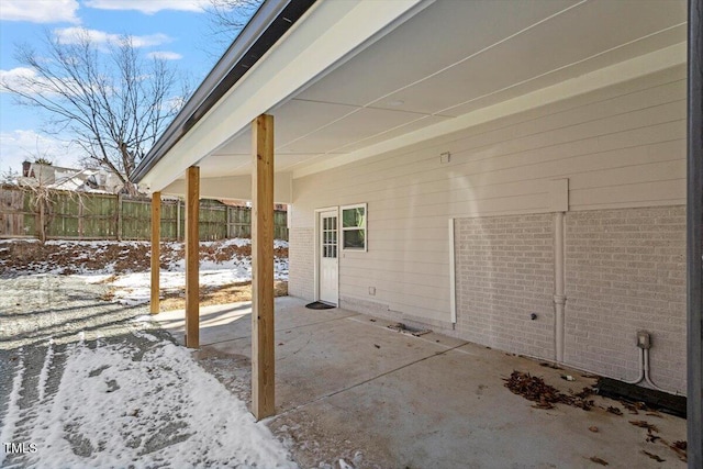 snow covered patio featuring fence