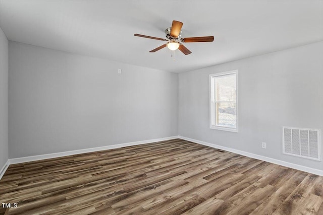unfurnished room with dark wood-style floors, ceiling fan, visible vents, and baseboards