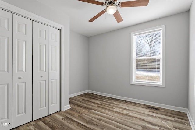 unfurnished bedroom with light wood-style floors, baseboards, visible vents, and a closet