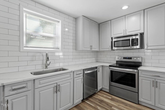 kitchen featuring stainless steel appliances, a sink, and white cabinetry