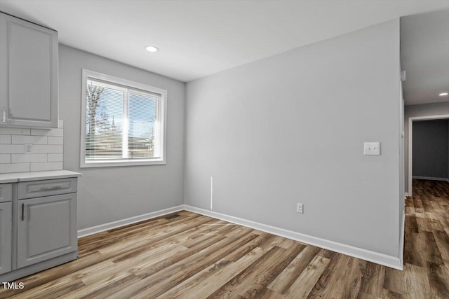 unfurnished dining area with recessed lighting, light wood-style flooring, and baseboards