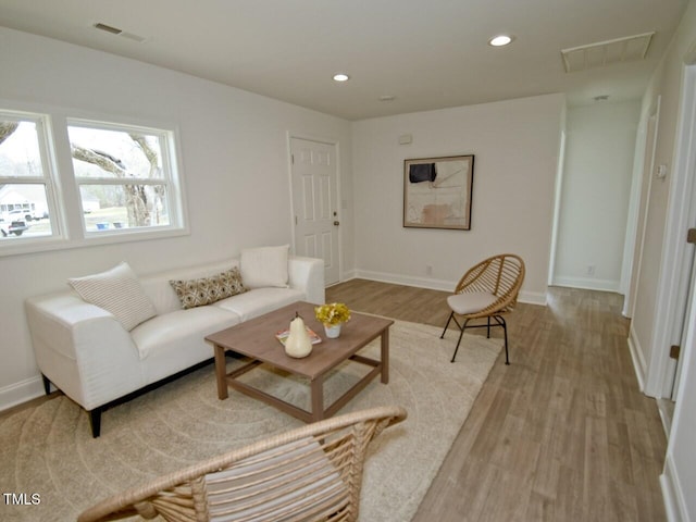 living room featuring recessed lighting, visible vents, light wood-style flooring, and baseboards