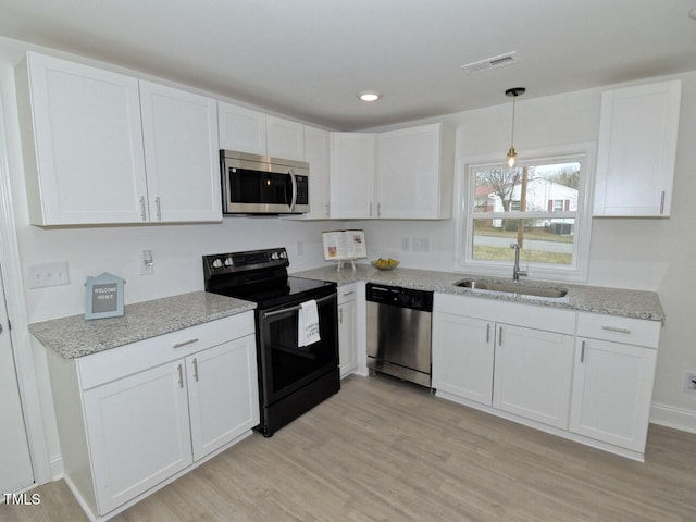 kitchen with stainless steel appliances, a sink, visible vents, and white cabinetry