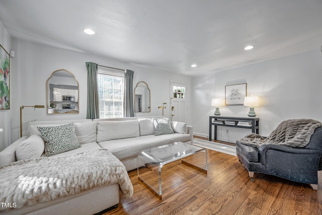 living area featuring baseboards, wood finished floors, and recessed lighting