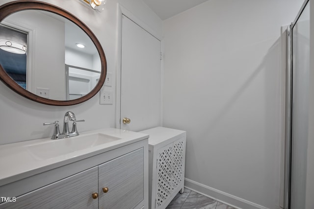 bathroom with marble finish floor, vanity, and baseboards