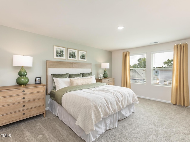 bedroom featuring light carpet, visible vents, and baseboards