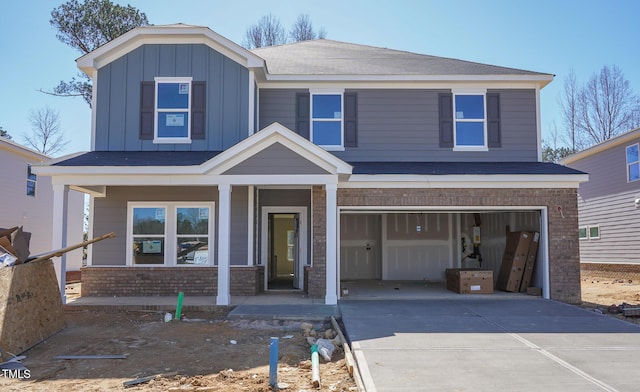 view of front of house featuring a porch, board and batten siding, concrete driveway, an attached garage, and brick siding