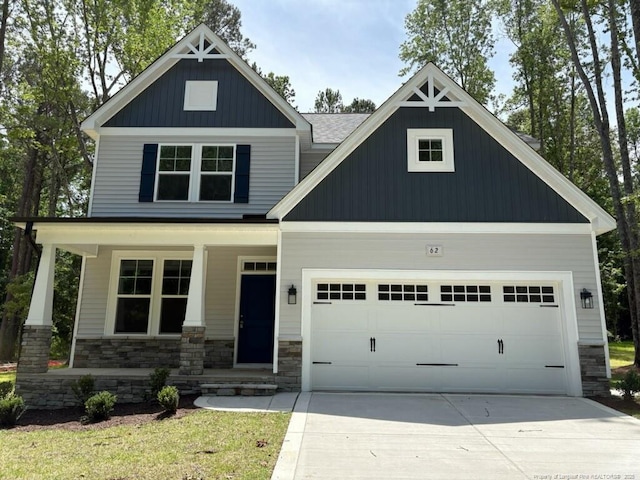 62 Peach Orchard Ln, Lillington, NC 27546 - craftsman-style house featuring covered porch, stone siding, concrete driveway, and a garage