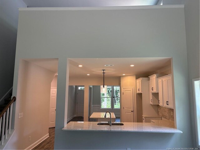 62 Peach Orchard Ln, Lillington, NC 27546 - kitchen with a sink, white cabinets, light stone counters, dark wood finished floors, and baseboards