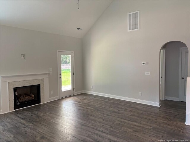 62 Peach Orchard Ln, Lillington, NC 27546 - unfurnished living room with high vaulted ceiling, arched walkways, dark wood-type flooring, a fireplace, and baseboards