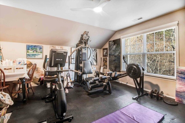 workout area featuring baseboards, visible vents, vaulted ceiling, and a ceiling fan